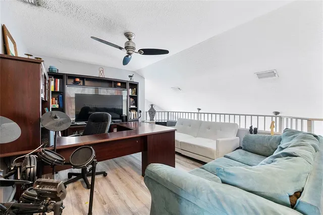 a view of a workspace with furniture and a window