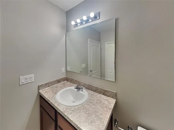 a bathroom with a granite countertop sink and a mirror