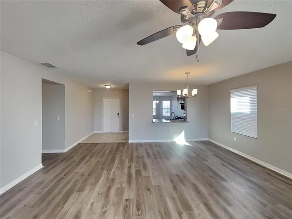 a view of empty room with wooden floor and window