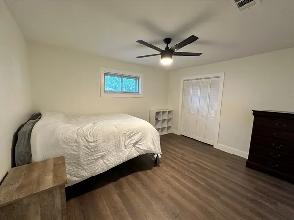 a spacious bedroom with a bed and a ceiling fan