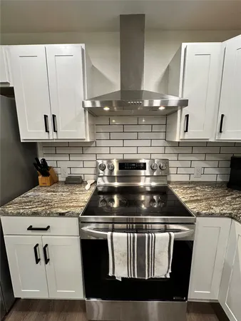 a large kitchen with stainless steel appliances granite countertop a lot of counter space a sink and cabinets