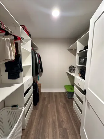 a view of walk in closet with clothes and shoes
