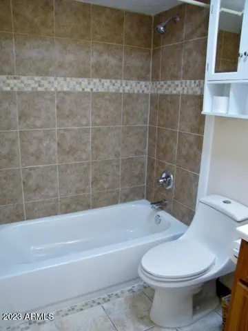 a white toilet and tub sitting next to a bathroom sink