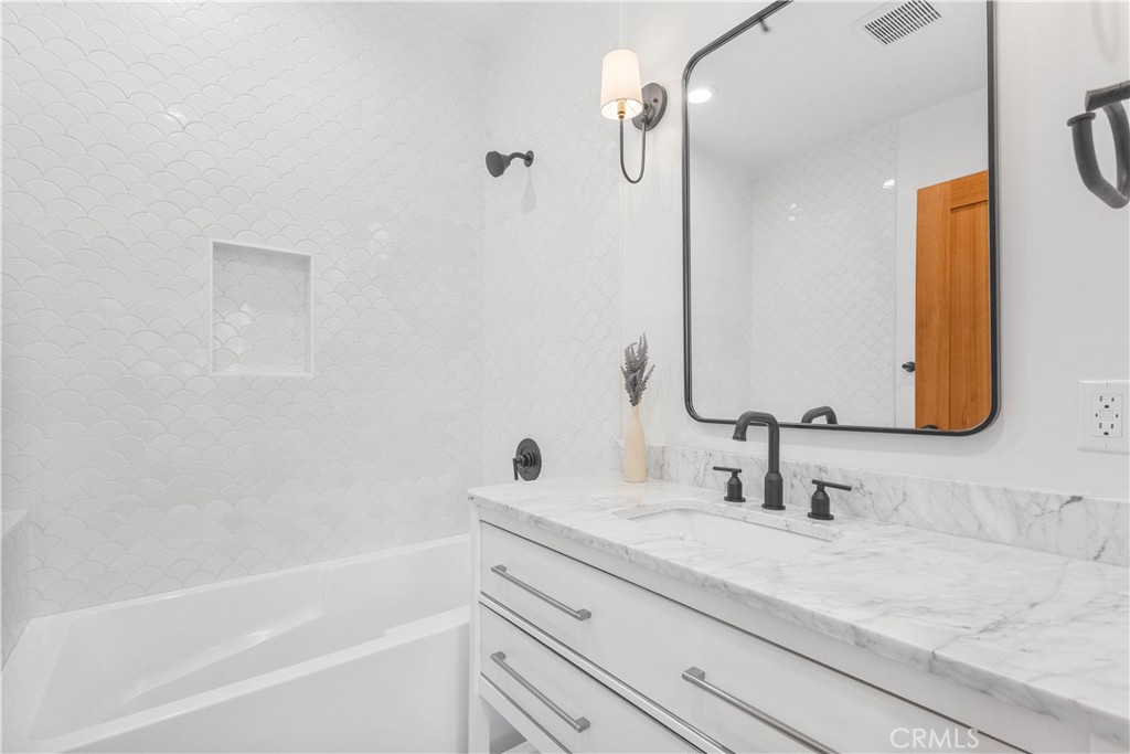 109 Painter Street Pasadena, CA 91103 - Photo 26 of 30 a bathroom with a granite countertop sink a mirror and a bathtub