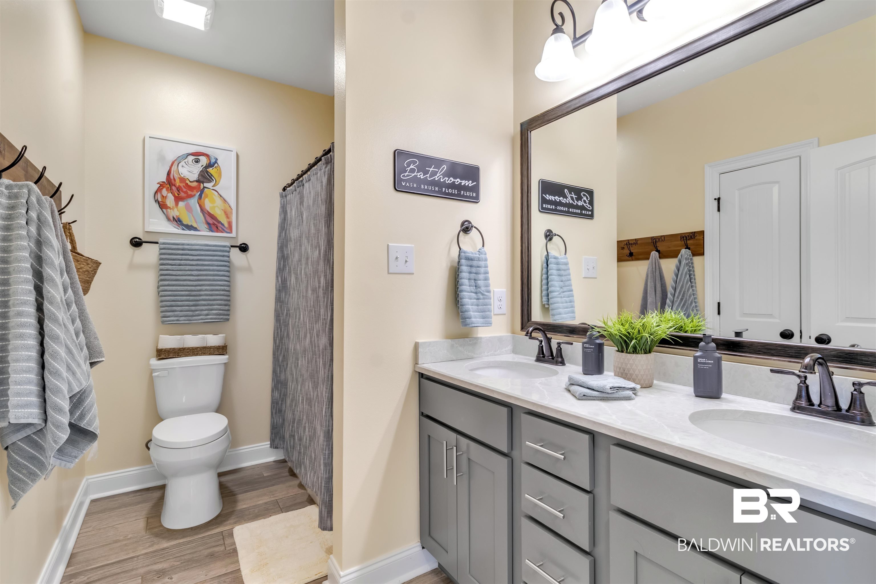 22531 Putter Lane Foley, AL 36535 - Photo 29 of 43 Full bathroom with double vanity, a shower with curtain, and light wood finished floors