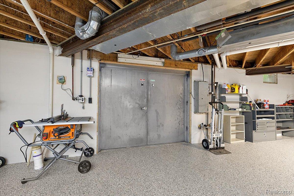 4219 Gardner Road Metamora, MI 48455 - Photo 53 of 84 Utility space featuring a durable speckled epoxy floor, exposed ceiling joists, and a metal double door