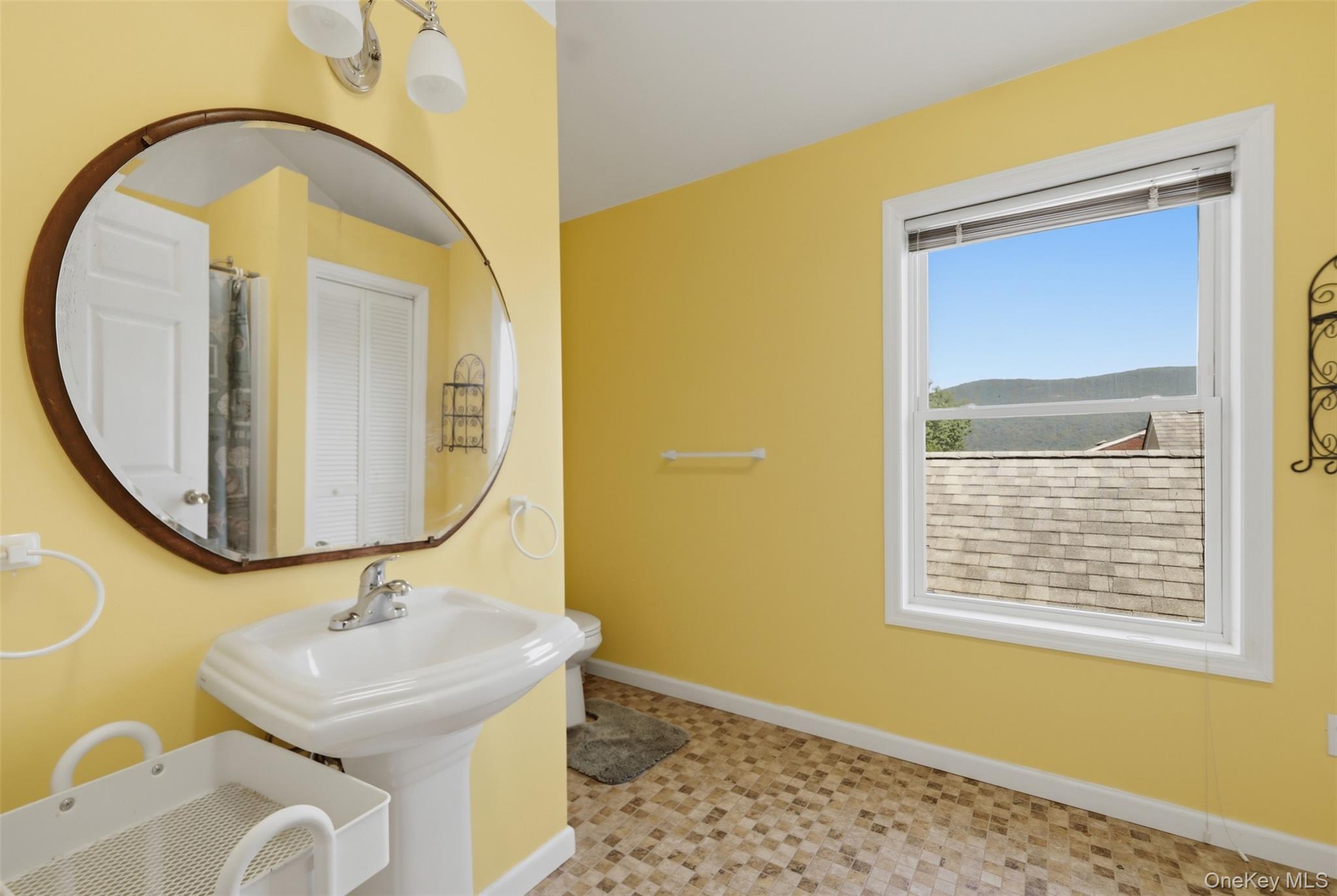 1 Hiko Place Fishkill, NY 12524 - Photo 30 of 41 Bathroom featuring a pedestal sink, oval mirror with wood-finish frame, and window with a mountain backdrop