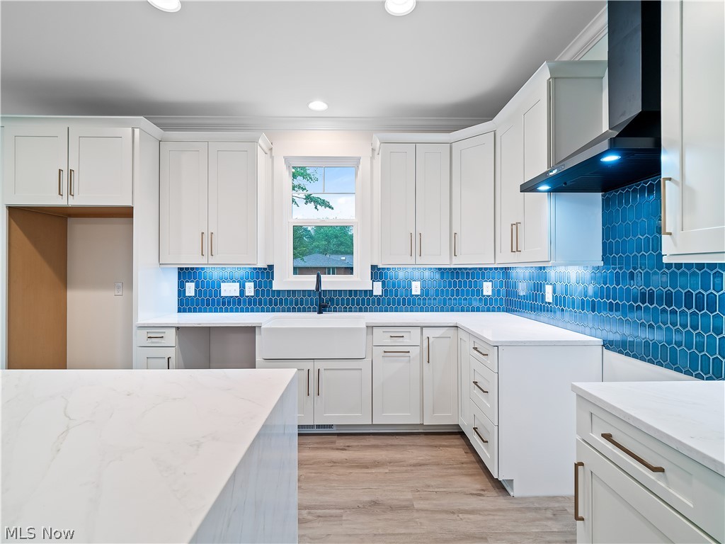 32 Brookside Lane North Ridgeville, OH 44039 - Photo 29 of 50 Kitchen with white cabinetry, tasteful backsplash, light stone counters, wall chimney exhaust hood, and recessed lighting