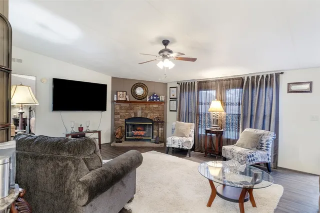a living room with furniture a flat screen tv and a fireplace