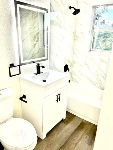 a bathroom with a sink mirror vanity and toilet