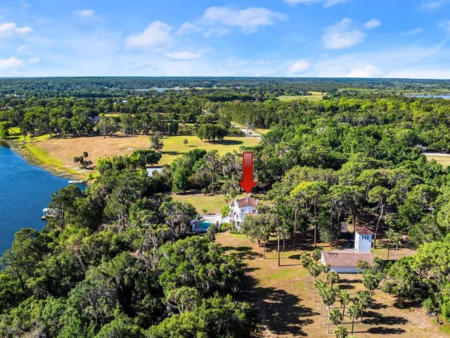 a living room with furniture a chandelier and kitchen view