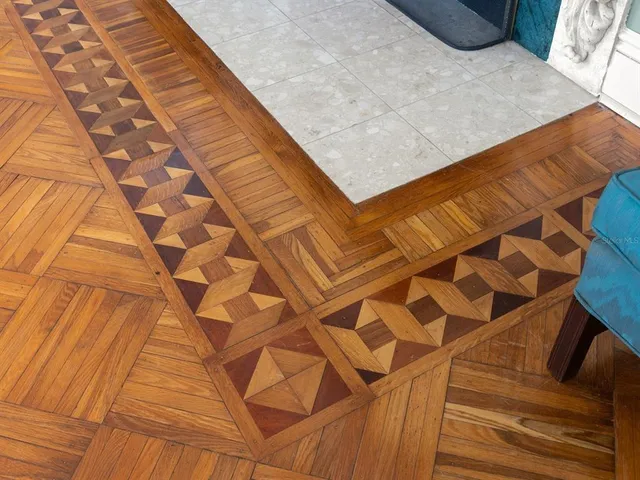 a view of a white house with a big yard and potted plants