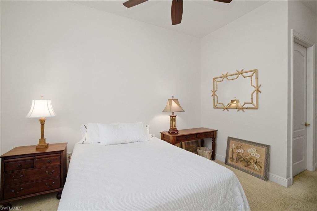 17015 Porta Vecchio Way, Unit 101 Naples, FL 34110 - Photo 11 of 39 a bedroom with a bed and a lamp on table