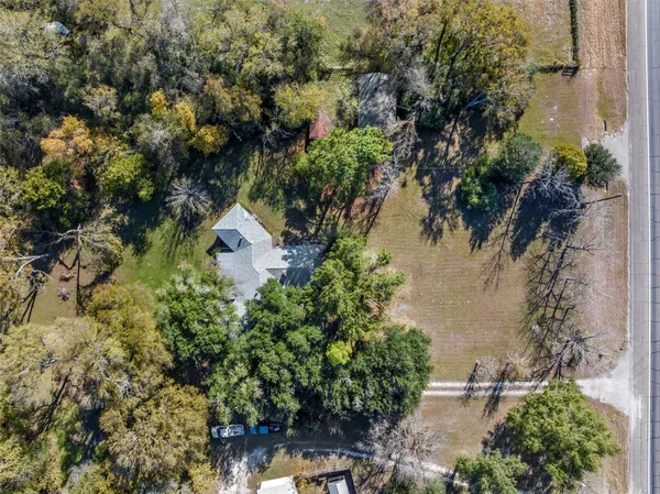 an aerial view of a house with a yard and lake view