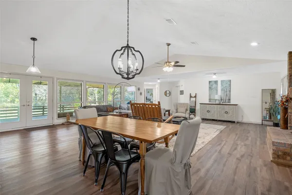 a dining room with furniture a chandelier and wooden floor