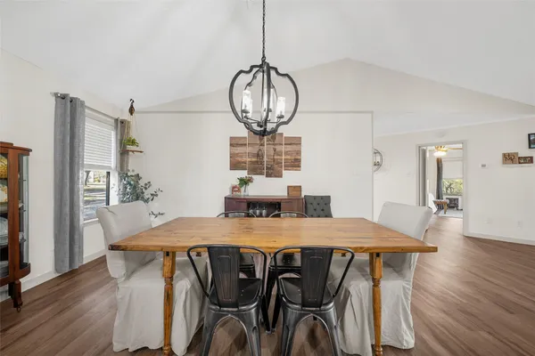 a view of a dining room with furniture a chandelier and wooden floor