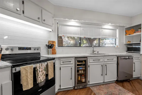 a kitchen with white cabinets and appliances