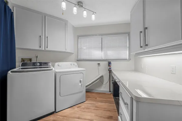 a utility room with cabinets washer and dryer