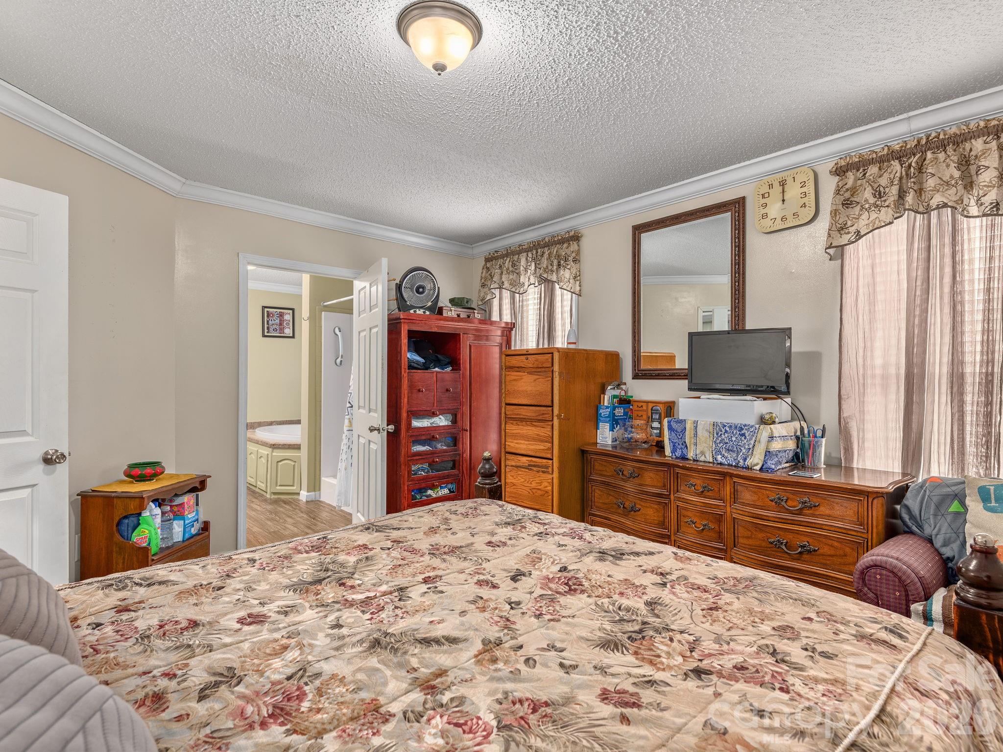 373 Starnes Cove Road Candler, NC 28715 - Photo 9 of 21 a bedroom with a bed and a flat tv screen on dresser