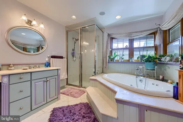 a spacious bathroom with a sink a bathtub a mirror and vanity