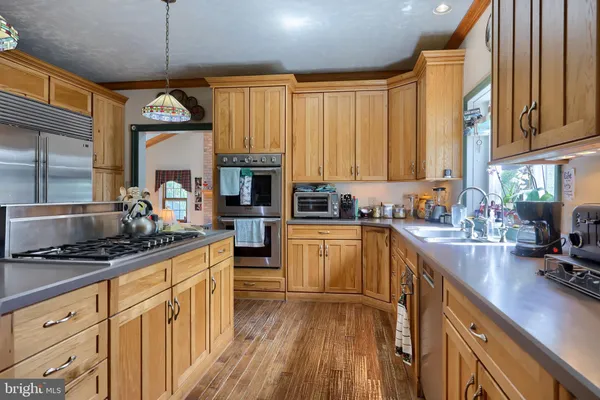a kitchen with stainless steel appliances a stove sink and cabinets