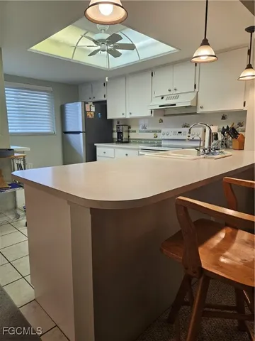 a kitchen with stainless steel appliances granite countertop a sink a stove and a refrigerator