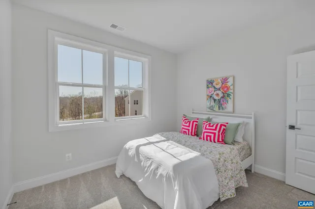 a bedroom with a bed and a large window