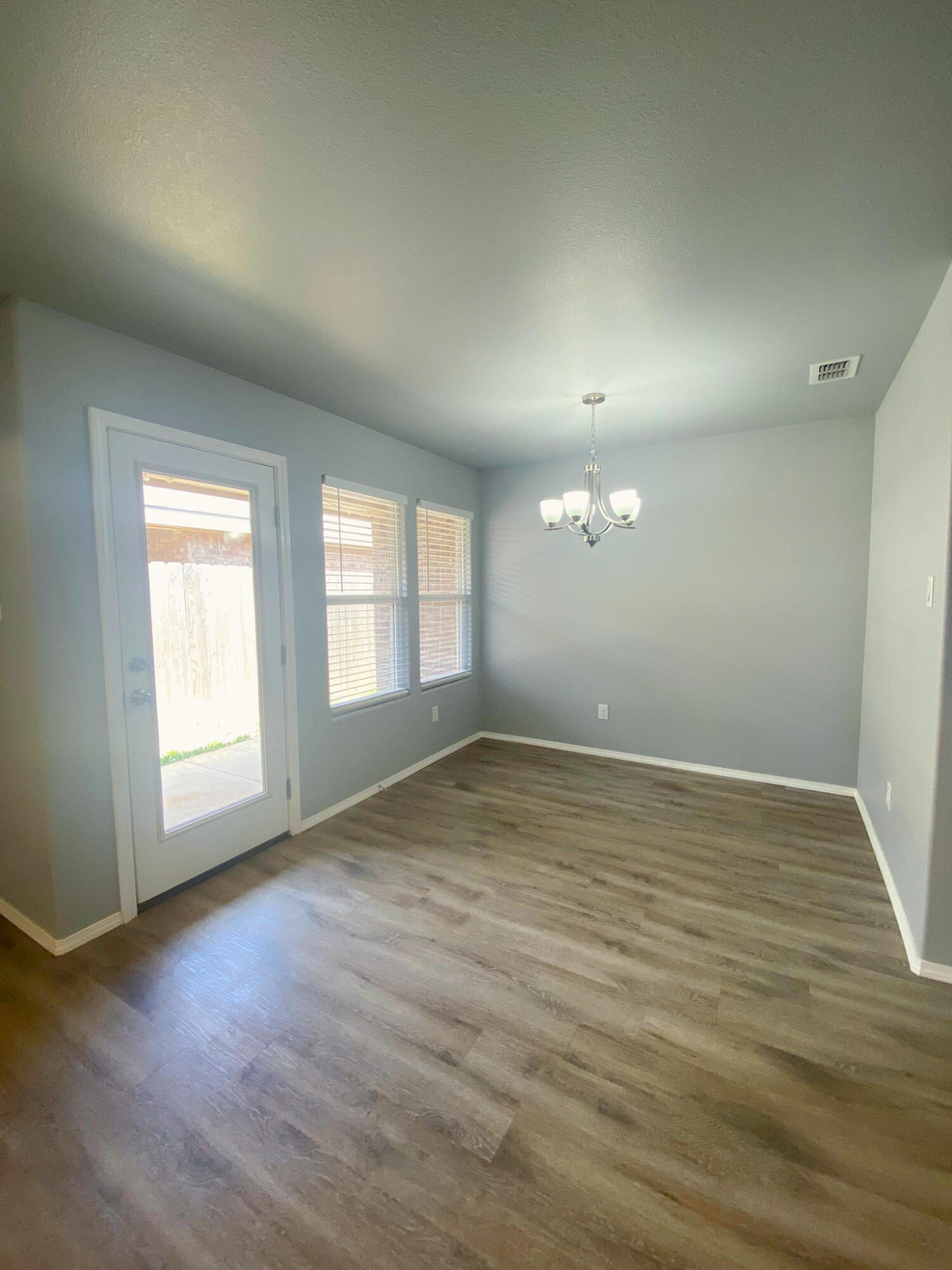 8605 10th Place Lubbock, TX 79416 - Photo 14 of 18 an empty room with wooden floor and windows