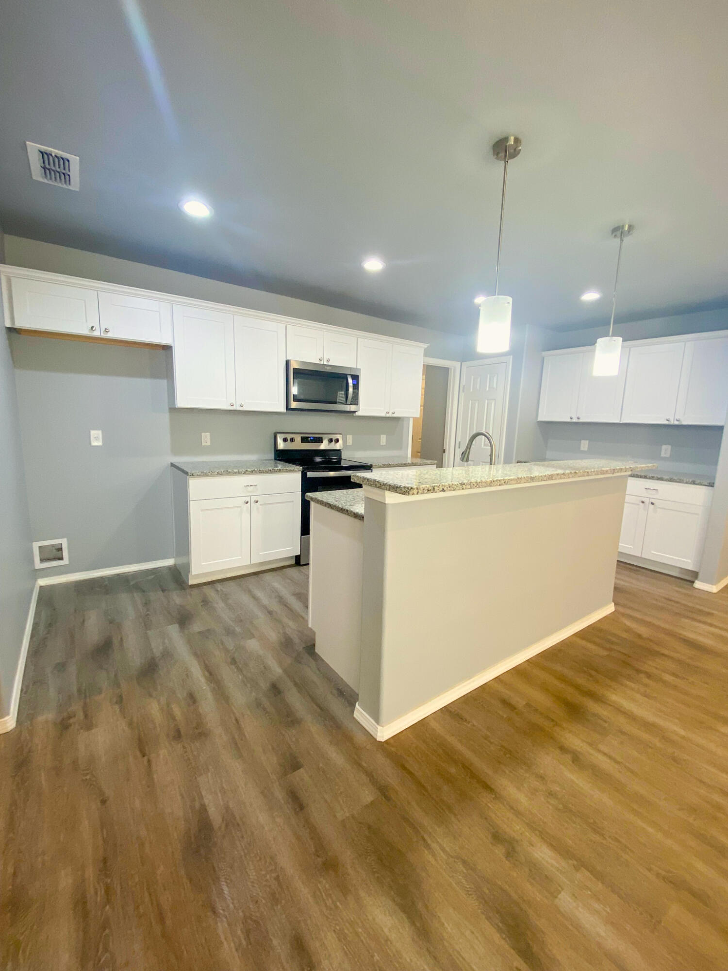 8605 10th Place Lubbock, TX 79416 - Photo 15 of 18 a kitchen with stainless steel appliances a stove top oven a sink a refrigerator and white cabinets