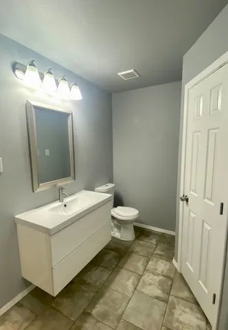 a bathroom with a sink mirror and toilet