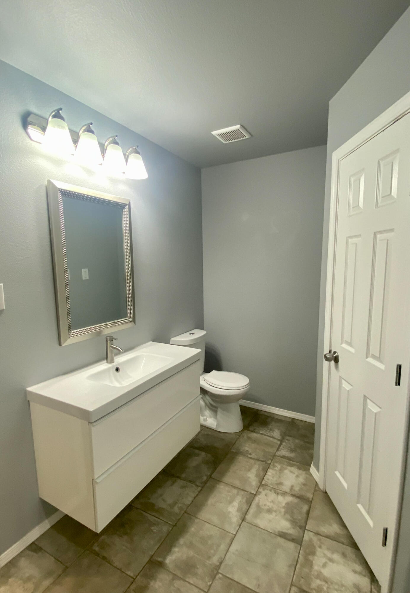 8605 10th Place Lubbock, TX 79416 - Photo 3 of 18 a bathroom with a sink mirror and toilet