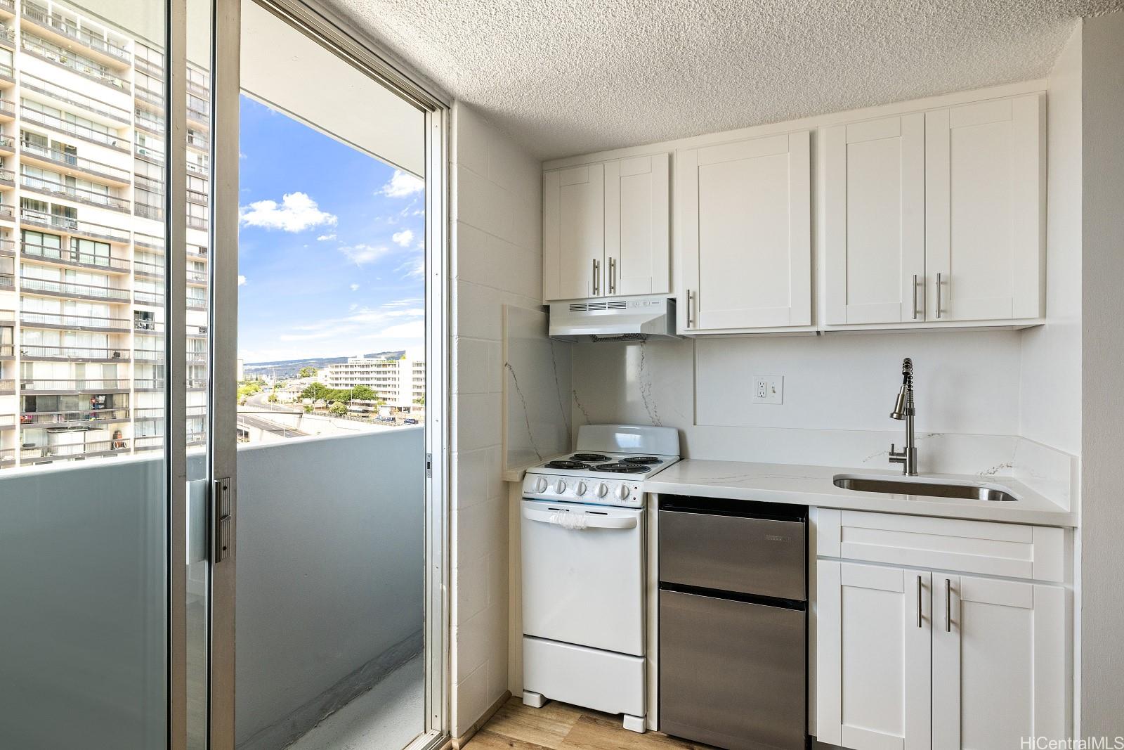 824 Kinau Street, Unit 902 Honolulu, HI 96813 - Photo 9 of 18 a kitchen with a white cabinets sink and a window