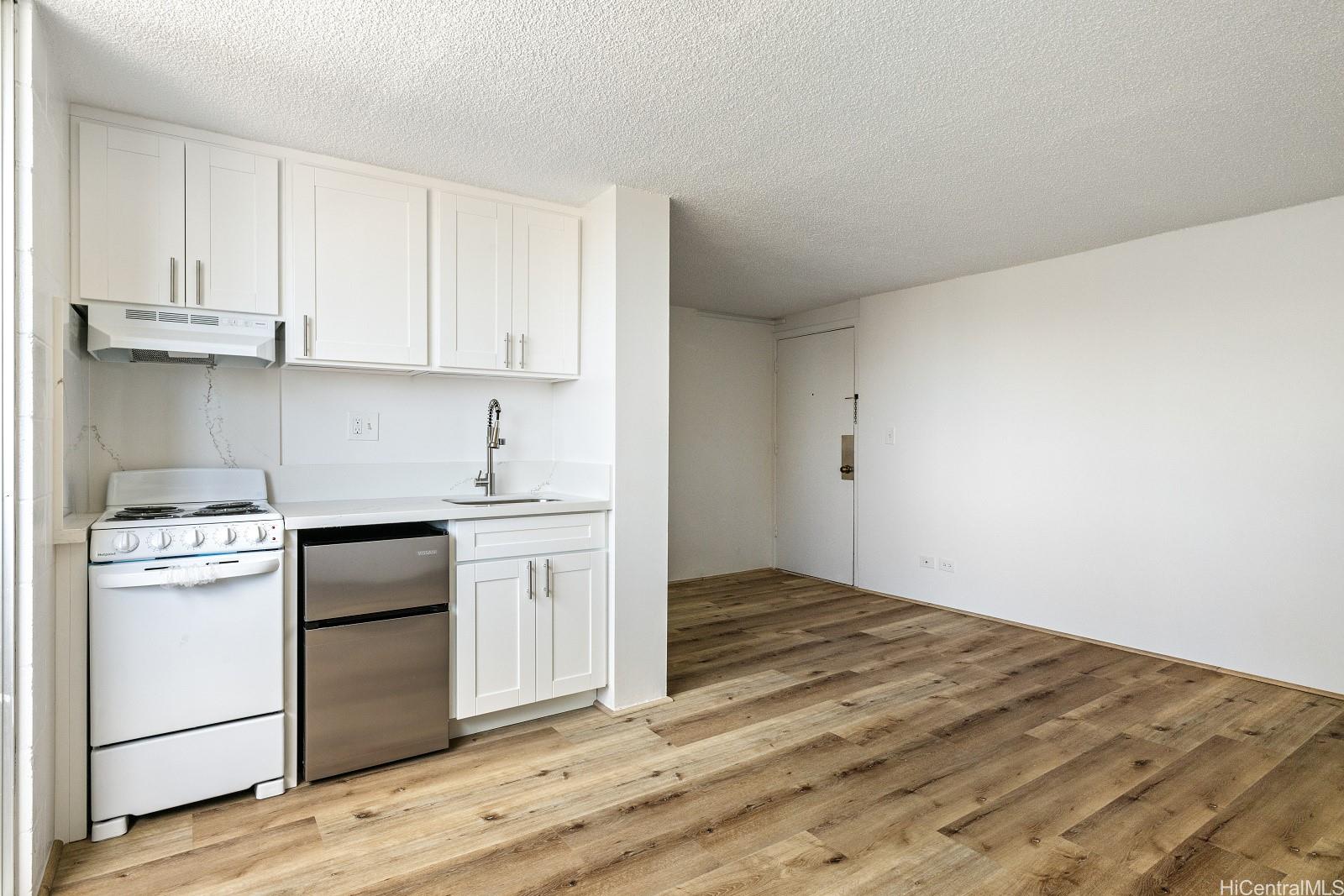824 Kinau Street, Unit 902 Honolulu, HI 96813 - Photo 10 of 18 a kitchen with granite countertop white cabinets and white appliances