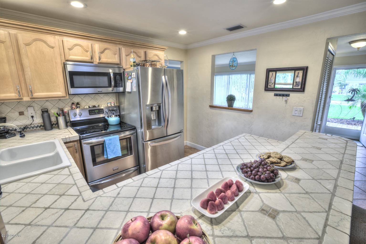 102 Marie Drive Ponce Inlet, FL 32127 - Photo 13 of 32 a kitchen with stainless steel appliances kitchen island granite countertop a refrigerator and a sink