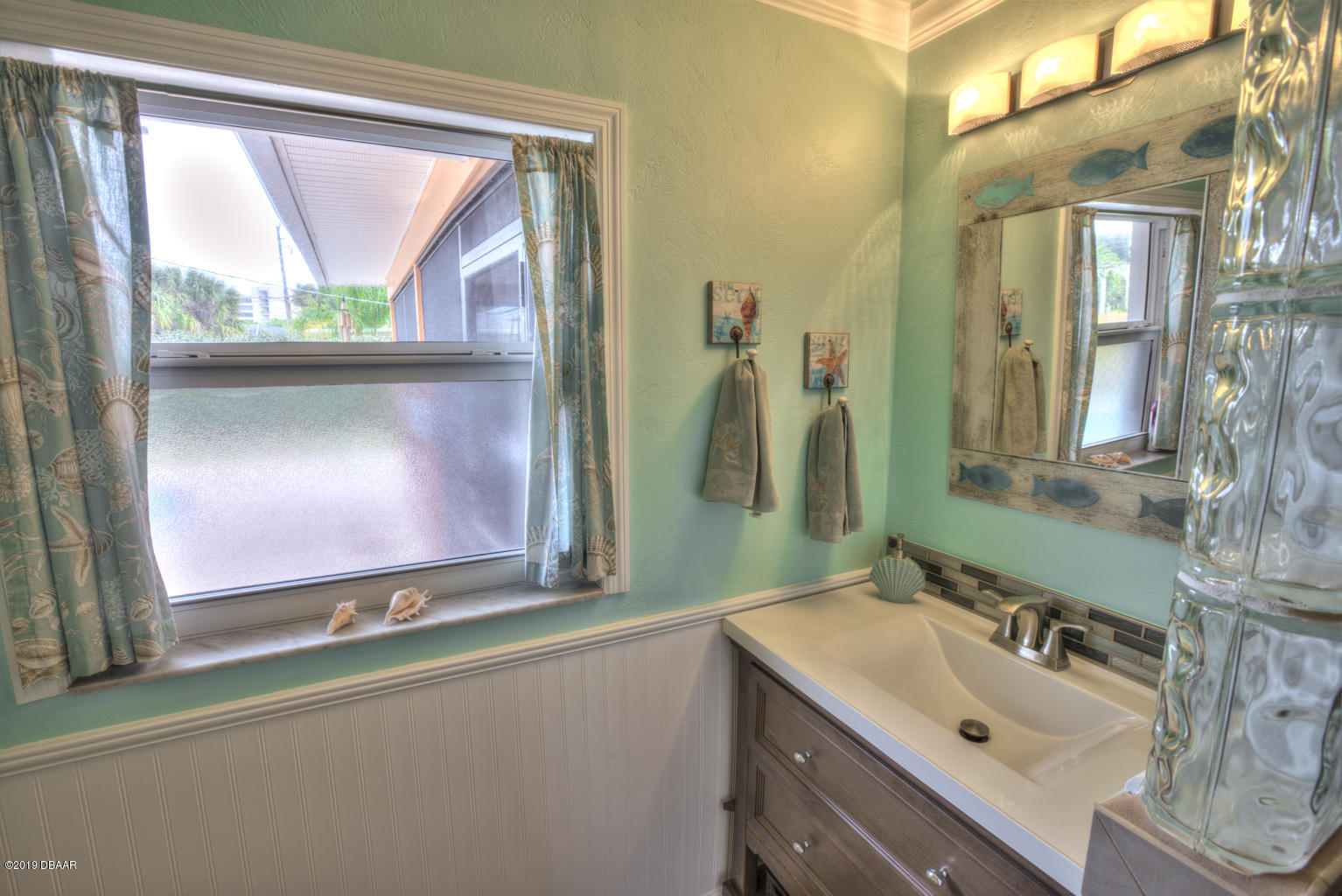 102 Marie Drive Ponce Inlet, FL 32127 - Photo 24 of 32 a bathroom with a sink mirror and window