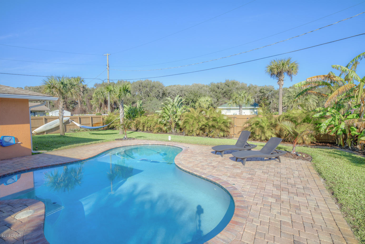 102 Marie Drive Ponce Inlet, FL 32127 - Photo 25 of 32 a view of a swimming pool with a yard and potted plants