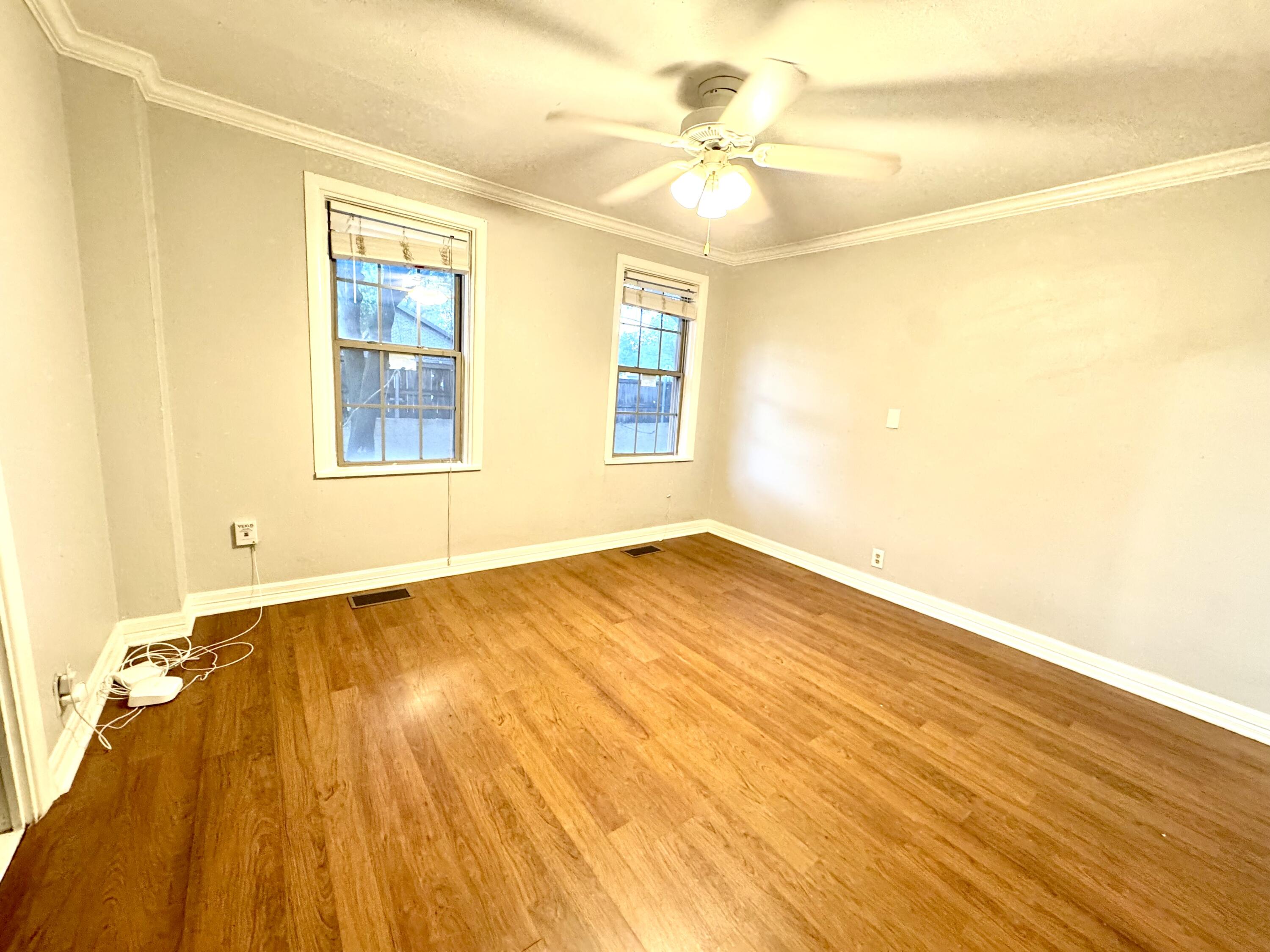 2702 23rd Street, Unit FRONT Lubbock, TX 79410 - Photo 11 of 22 a view of an empty room with wooden floor and a window