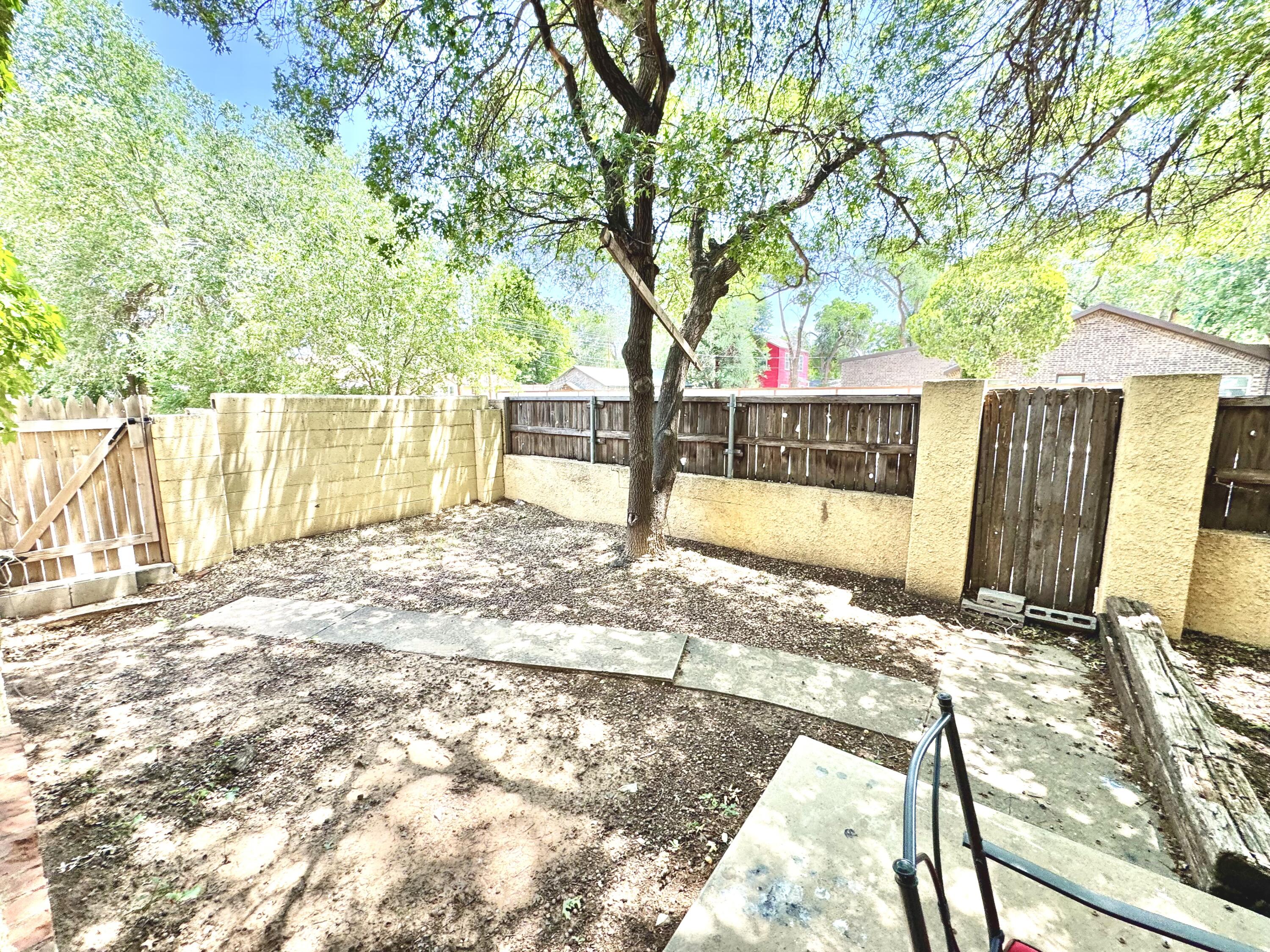 2702 23rd Street, Unit FRONT Lubbock, TX 79410 - Photo 20 of 22 a view of a backyard with large trees and wooden fence