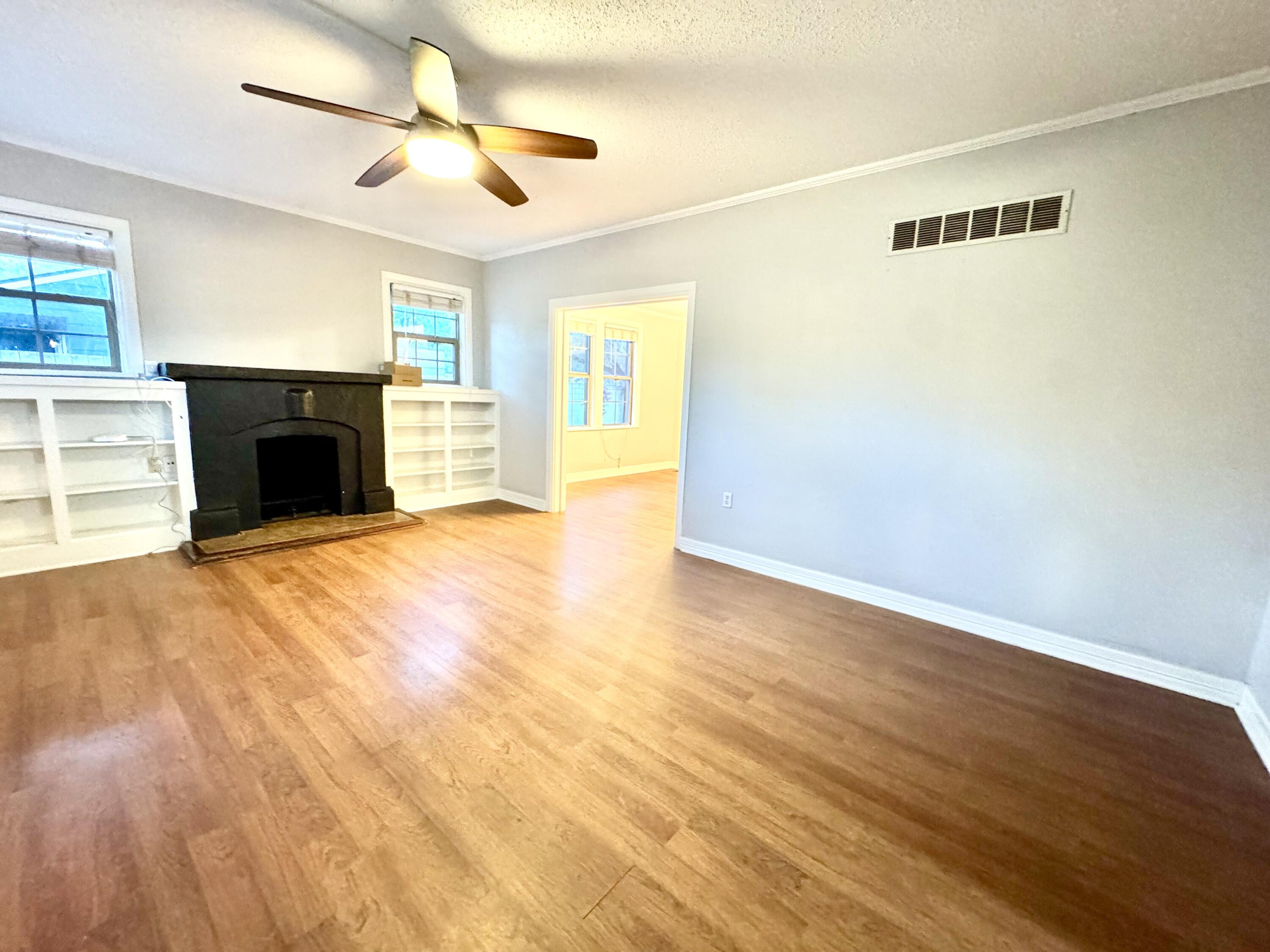 2702 23rd Street, Unit FRONT Lubbock, TX 79410 - Photo 2 of 22 a view of a livingroom with a fireplace a ceiling fan and wooden floor