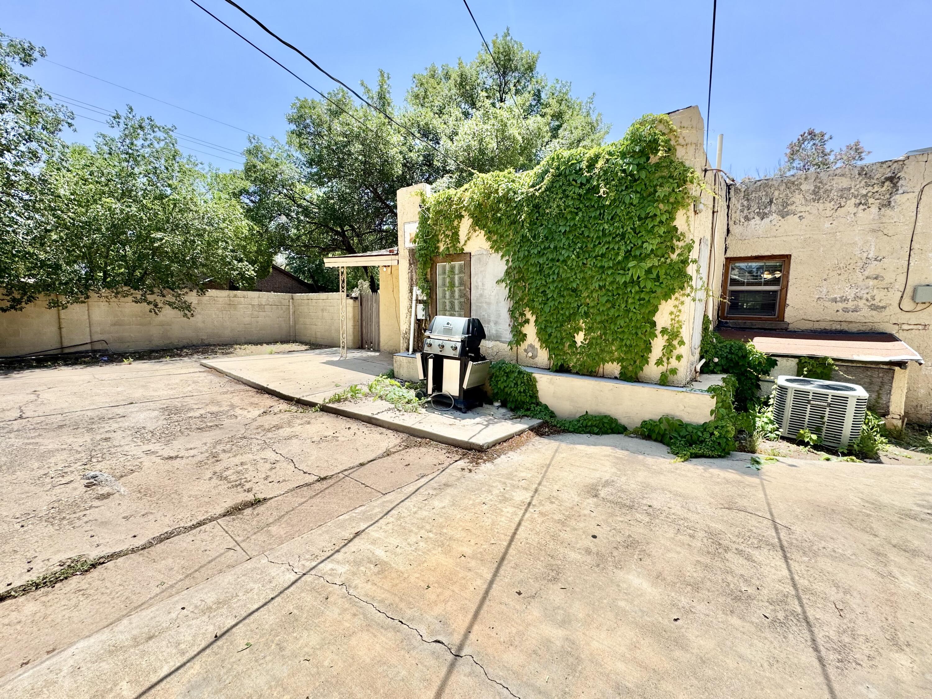 2702 23rd Street, Unit FRONT Lubbock, TX 79410 - Photo 22 of 22 a view of a patio with a table and chairs and potted plants