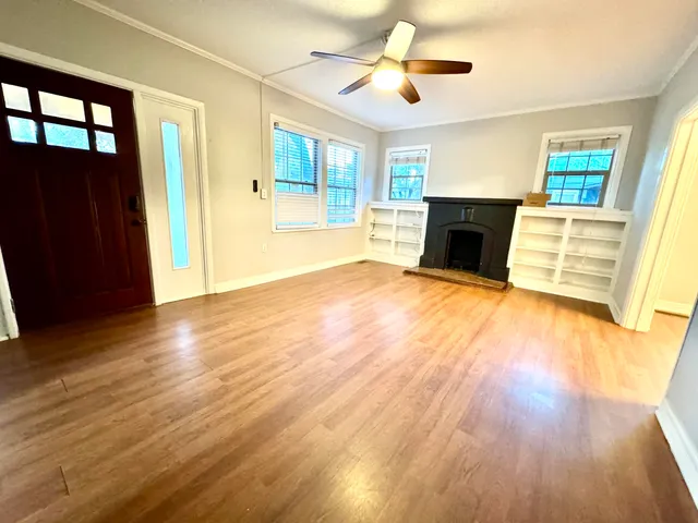 a view of empty room with wooden floor and fireplace
