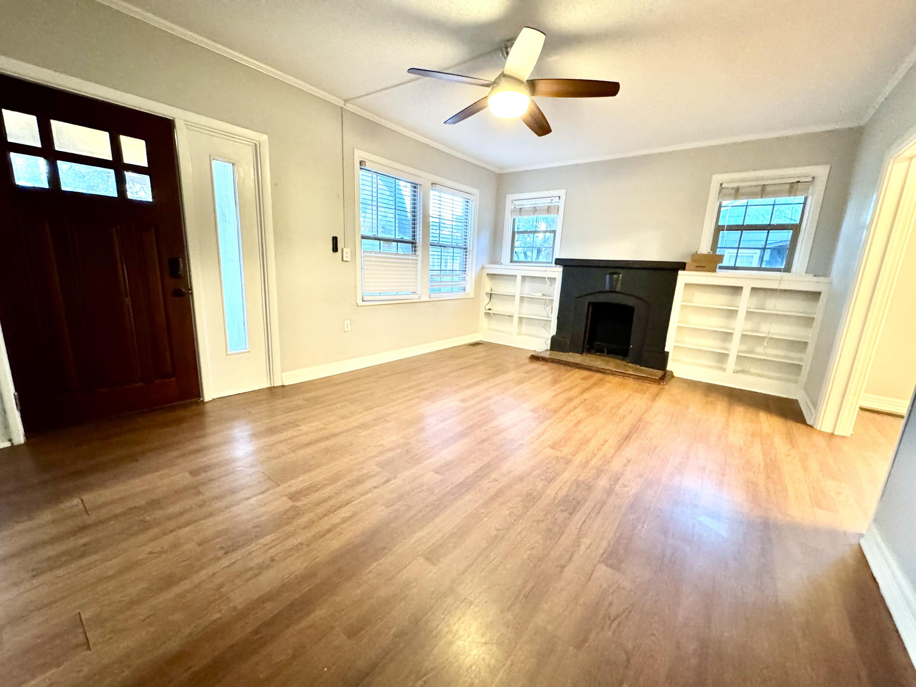2702 23rd Street, Unit FRONT Lubbock, TX 79410 - Photo 3 of 22 a view of empty room with wooden floor and fireplace