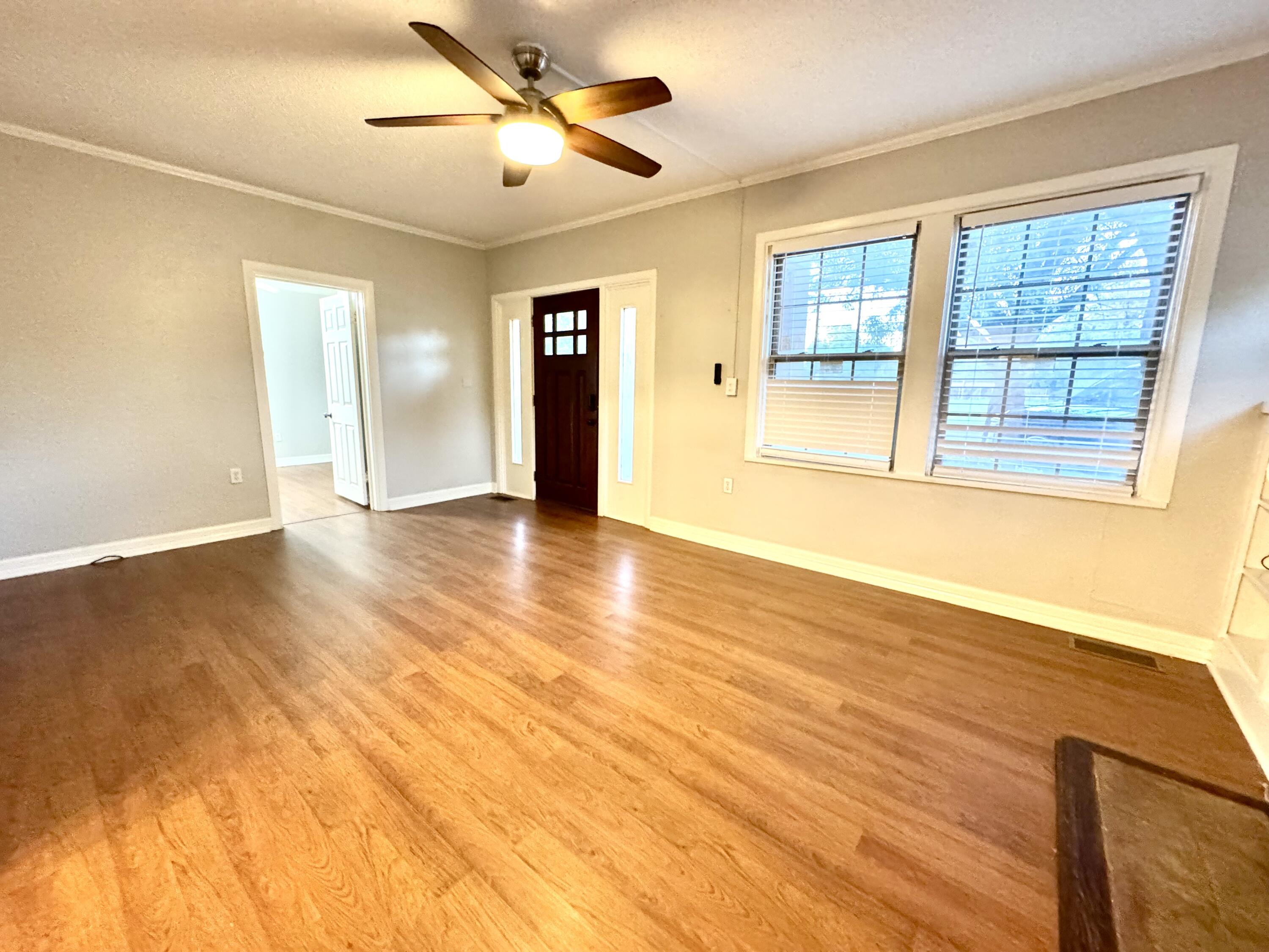 2702 23rd Street, Unit FRONT Lubbock, TX 79410 - Photo 4 of 22 a view of an empty room with wooden floor and a window