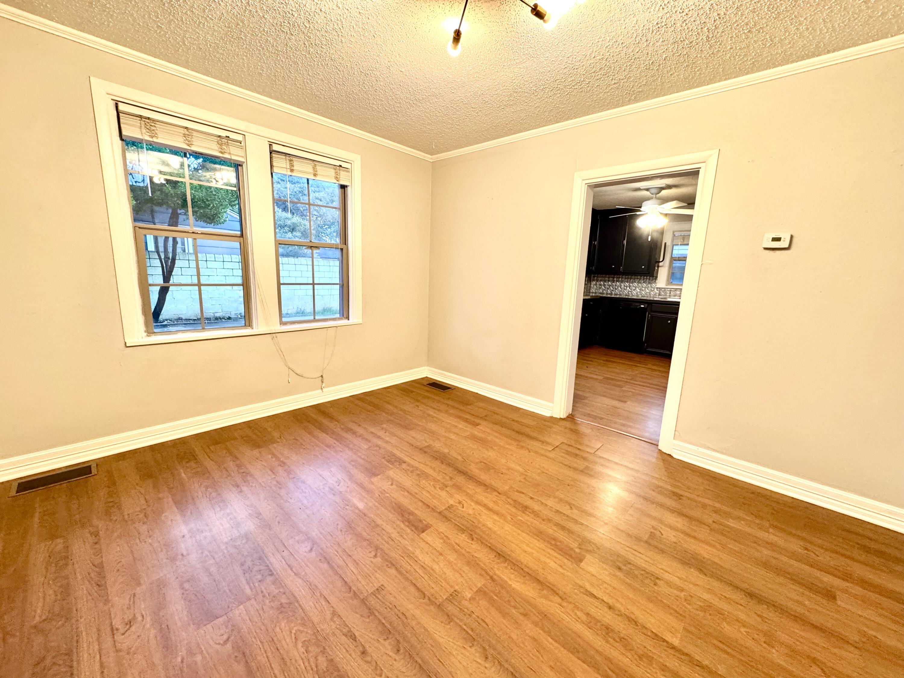 2702 23rd Street, Unit FRONT Lubbock, TX 79410 - Photo 6 of 22 an empty room with wooden floor and windows