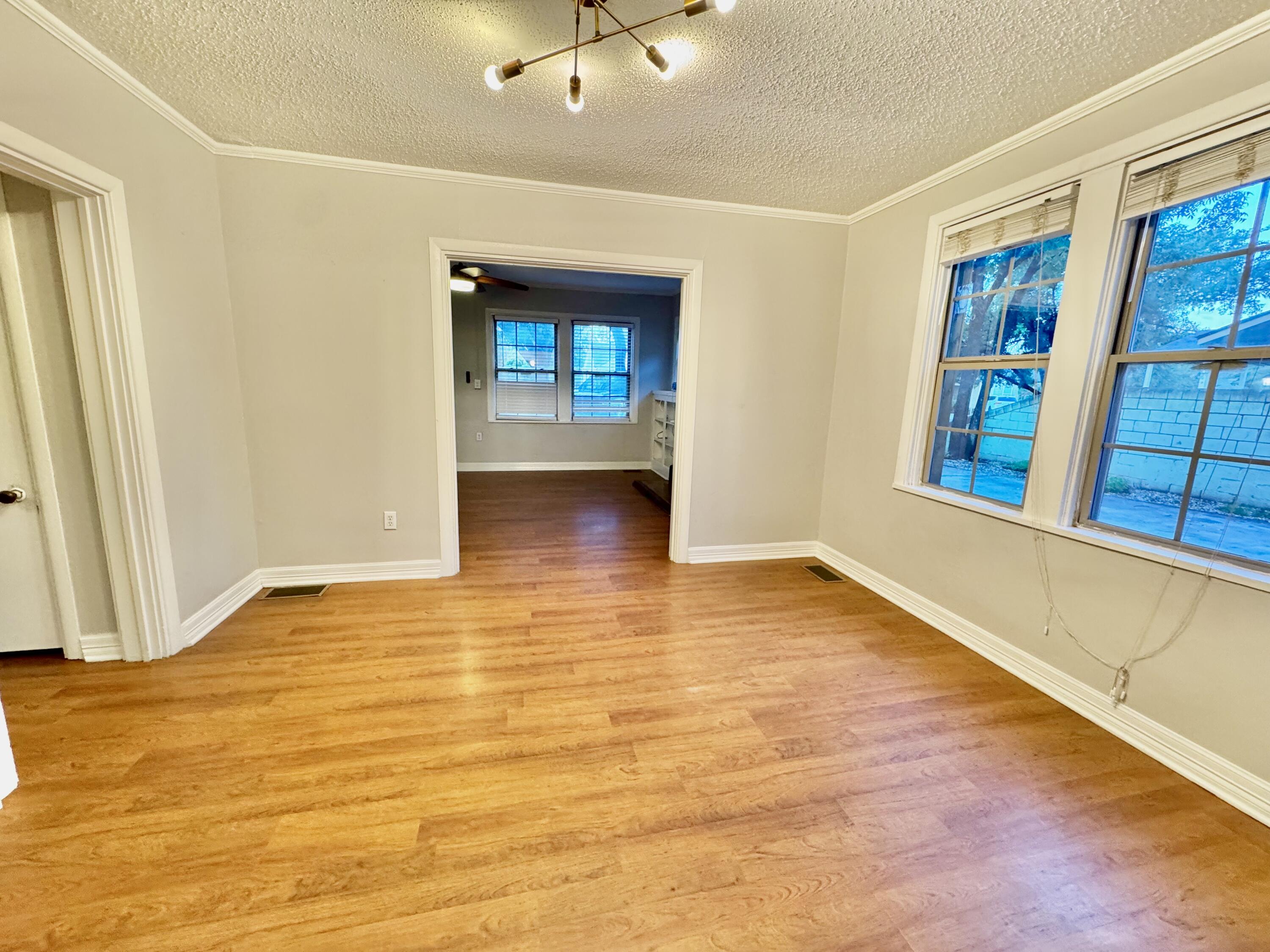2702 23rd Street, Unit FRONT Lubbock, TX 79410 - Photo 7 of 22 a view of an empty room with window and wooden floor