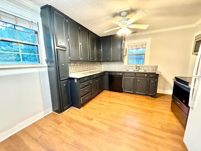 a large kitchen with granite countertop a stove a sink and a refrigerator