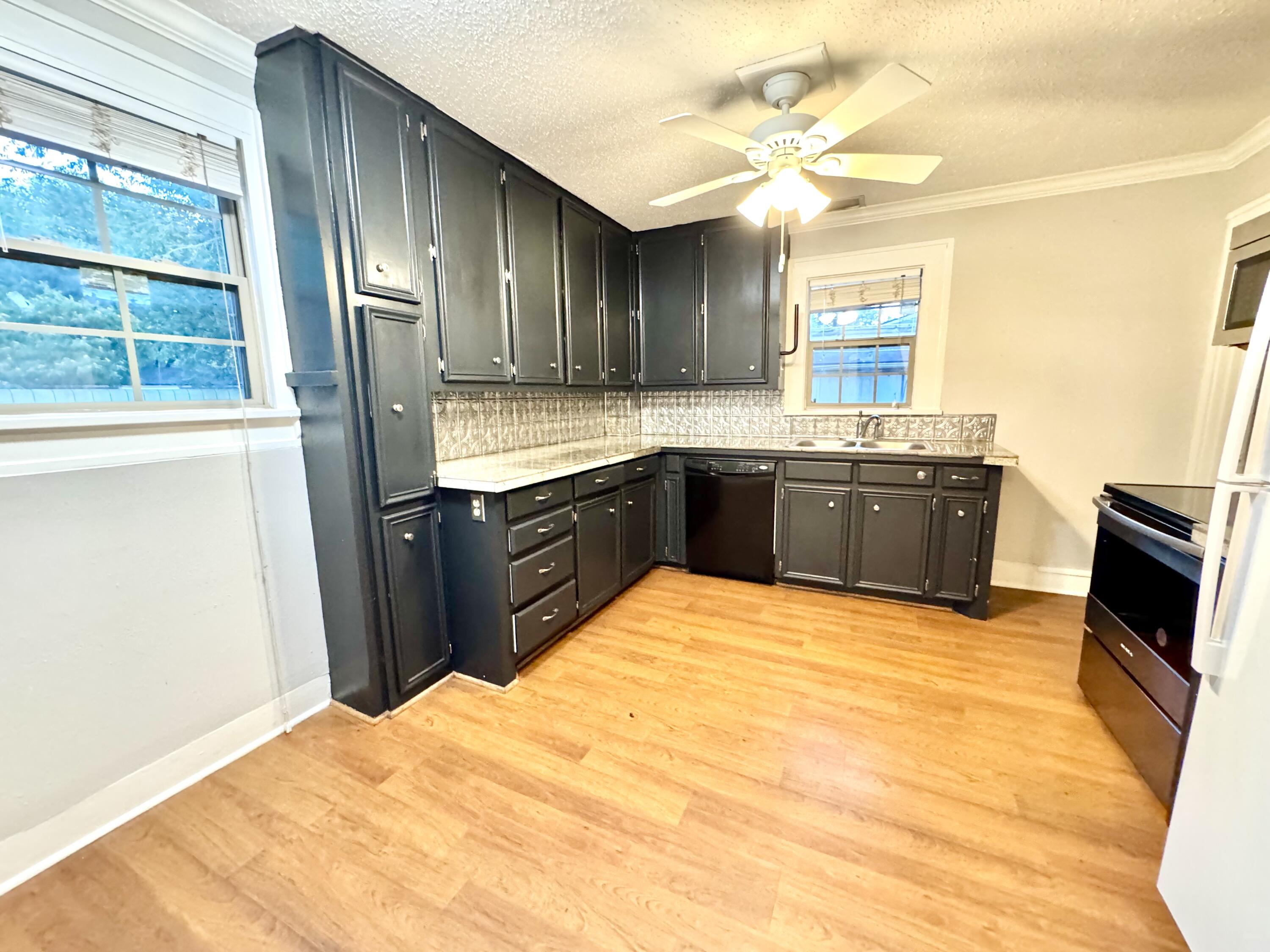 2702 23rd Street, Unit FRONT Lubbock, TX 79410 - Photo 8 of 22 a large kitchen with granite countertop a stove a sink and a refrigerator