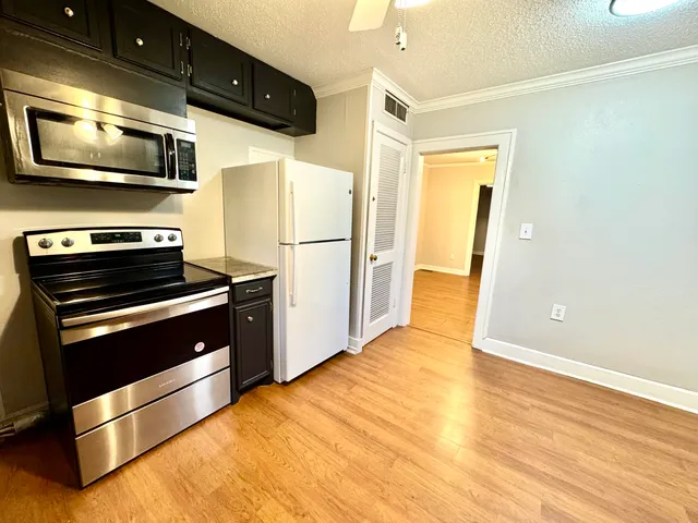 a kitchen with stainless steel appliances a microwave a stove and a refrigerator