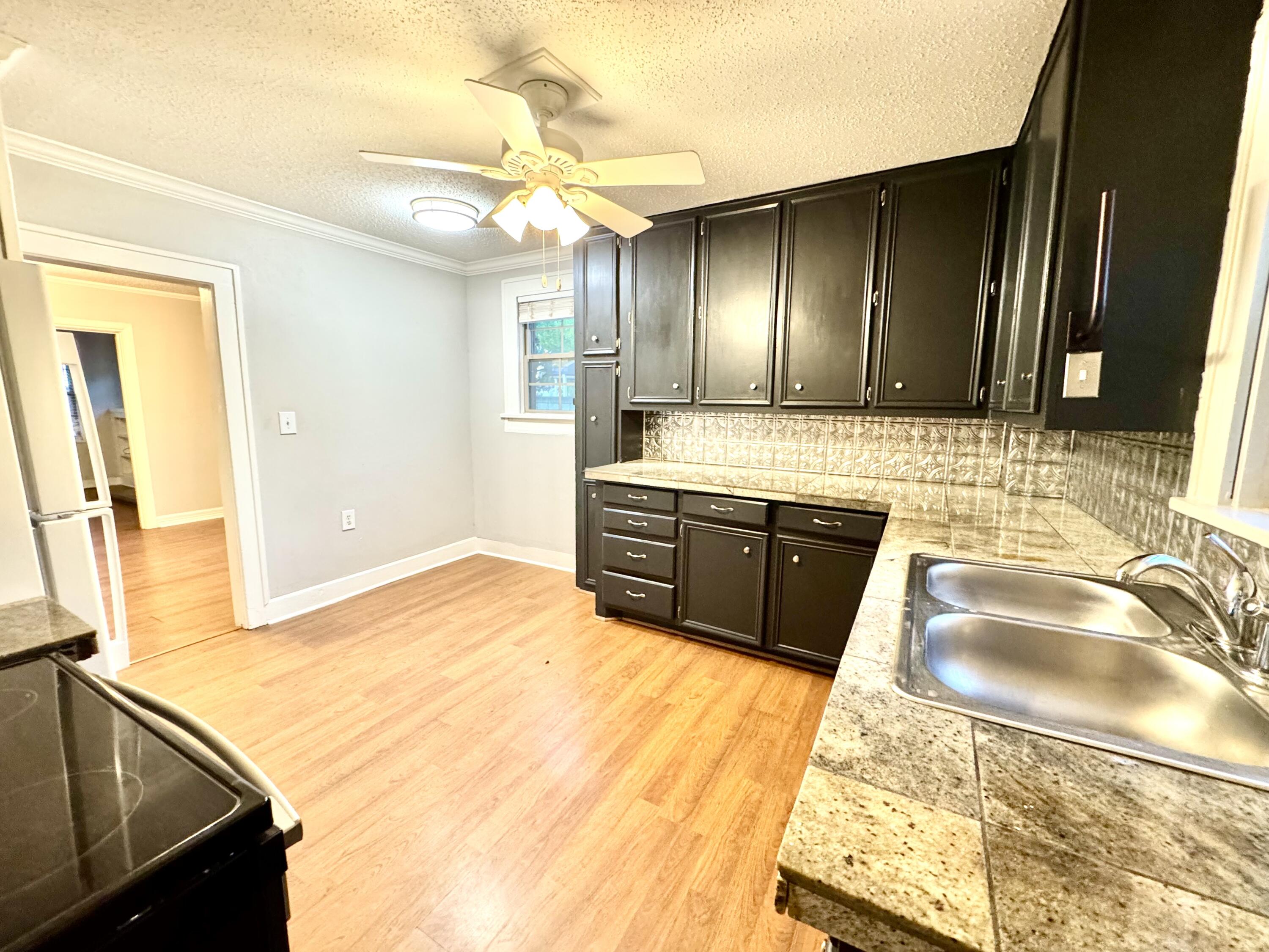 2702 23rd Street, Unit FRONT Lubbock, TX 79410 - Photo 10 of 22 a bathroom with a granite countertop sink and a mirror
