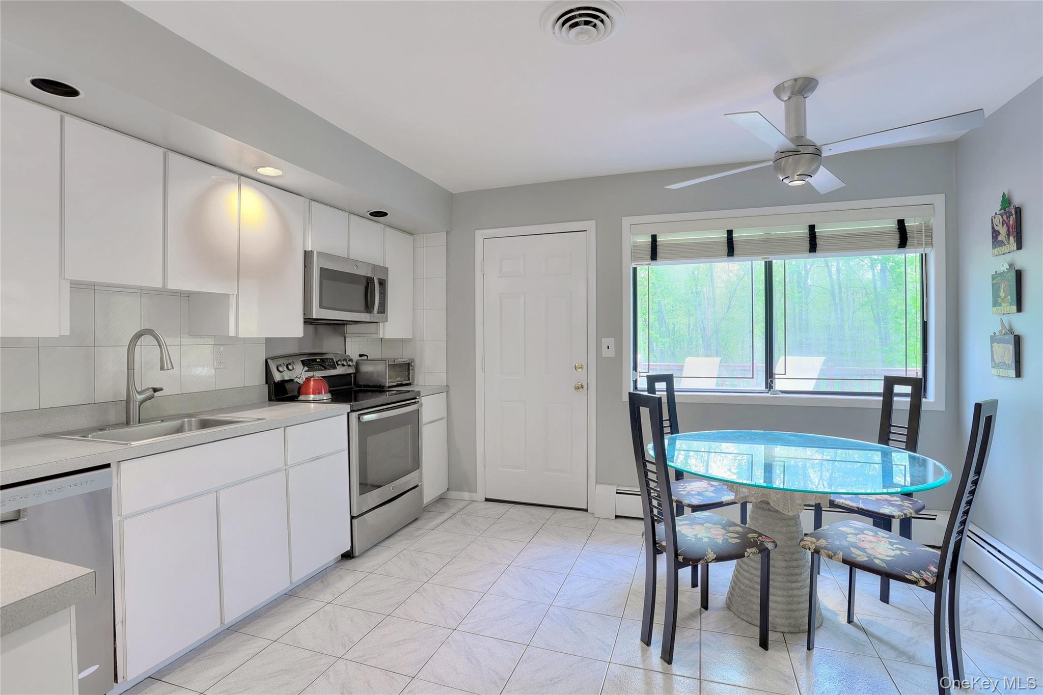 47 Camp Hill Road Pomona, NY 10970 - Photo 11 of 30 a kitchen with a table chairs microwave and cabinets